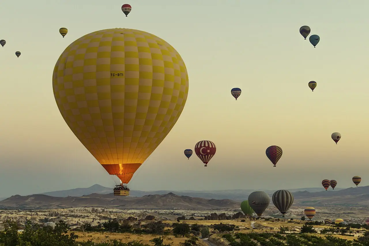 Hot-air balloons rising at sunrise over Göreme in Cappadocia.