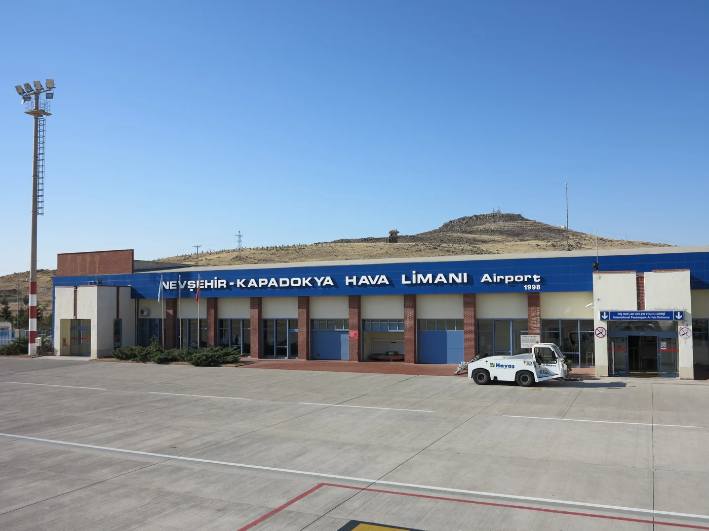 Nevşehir Kapadokya Airport terminal exterior under a clear blue sky.